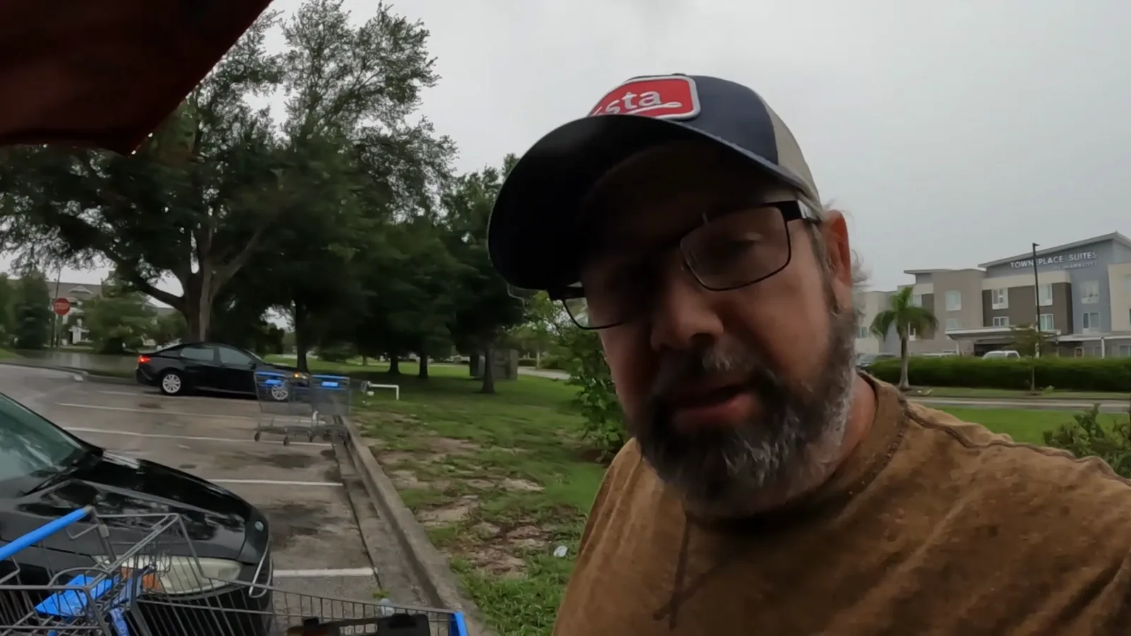 Derek beside his truck while replacing a failed battery during rainy weather